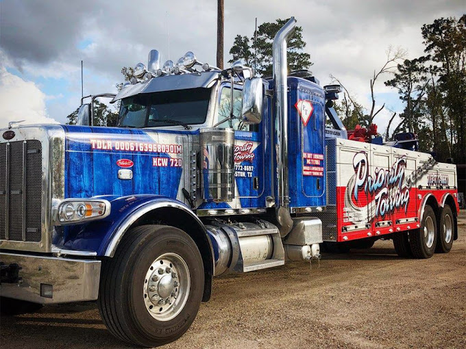 Priority Towing medium-duty wrecker towing a commercial vehicle